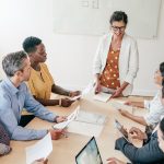 image of a woman leading a sales team meeting to show The Changing Role of Sales Leadership in 2026