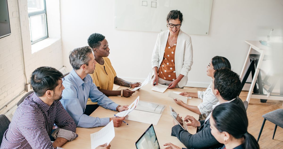 image of a woman leading a sales team meeting to show The Changing Role of Sales Leadership in 2026